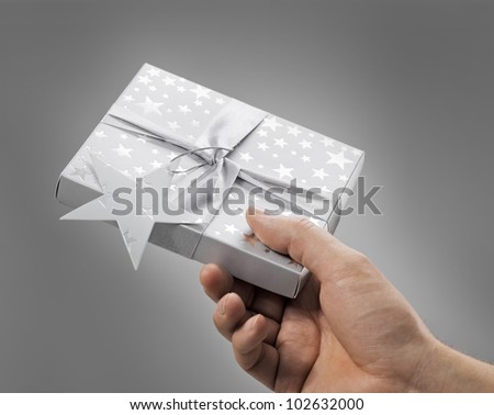 Man holding a gift box (contains a CD) in his hand.