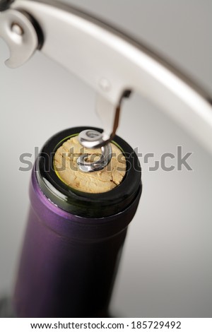 Cork of a wine bottle and a waiter\'s Bow-style corkscrew. Very short depth-of-field.