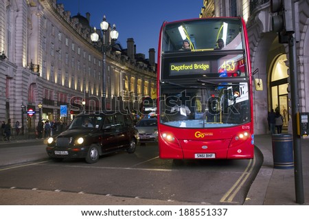 LONDON, UK - APRIL 16, 2014: London transport, Black taxi cab and red double-decker bus at Piccadilly Circus.