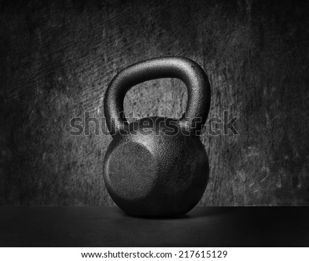 Black and whit image of a rough and tough heavy 30 kg 66 lbs cast iron kettlebell.