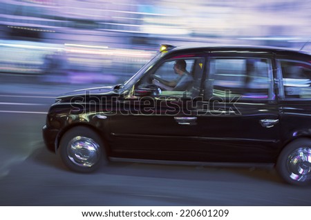 LONDON, UK - APRIL 16, 2014: Blurry image of a London taxi cab moving on a street.