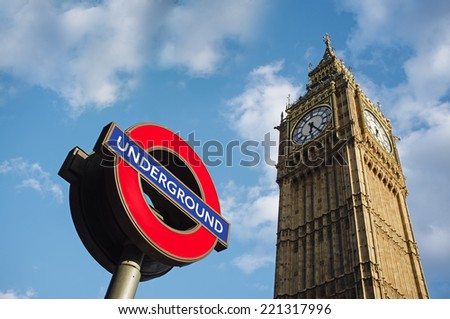 LONDON, UK - APRIL 14, 2014: Symbols of London - Underground sign and Big Ben clock tower.