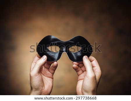 Man holding a black eye mask in his hands.