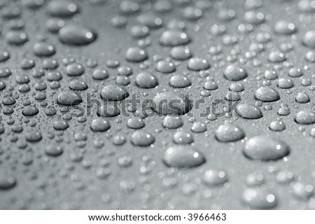 Droplets on a car. Short depth of field. The image may appear grainy, but it's caused by the metallic paint.