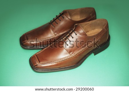 Men's brown leather dress shoes photographed with ring flash. Short depth of field.