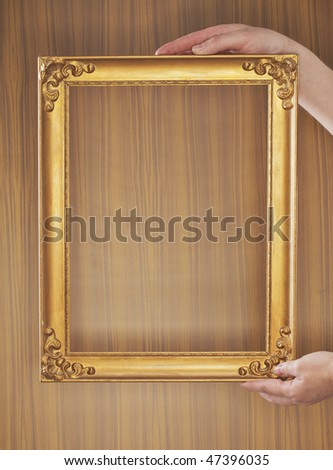 Hands holding a vintage gold colored frame