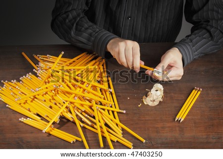 Man sharpening pencils with a pencil sharpener