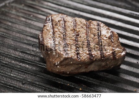 Beef tenderloin steak with pepper on a grill pan.