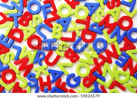 Plastic colorful random letters on white background.