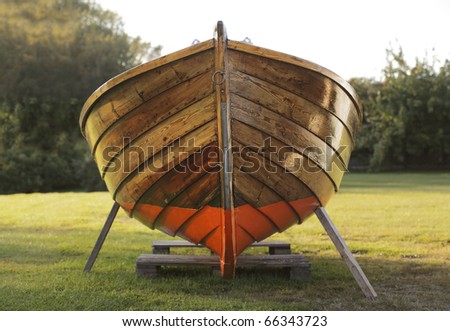 Old wooden boat winter storaged on lawn.