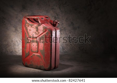 Old, dirty and rusty red jerry can fuel container.