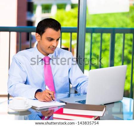 Portrait of a busy guy multitasking, taking notes, reading paper, surfing internet with laptop, isolated on a city background with trees