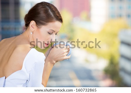 Closeup portrait of beautiful, happy, relaxed woman enjoying a weekend on sunny day, on balcony of her apartment isolated on city background. Urban life style of businesswoman, corporate professional.