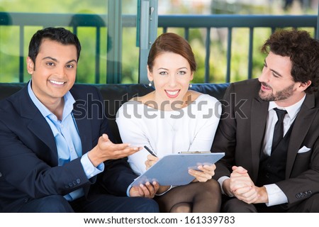 Picture of a manager, financial consultant, banker presenting to a young smiling couple a business investment opportunity plan, offering to sign it, isolated on background of city. Finance decisions