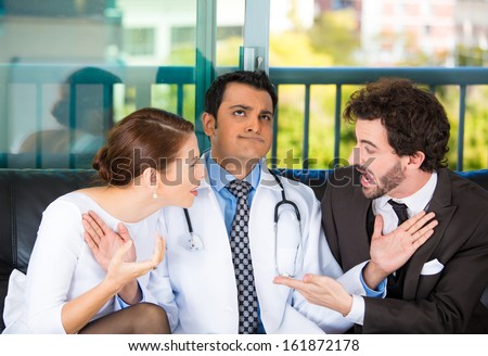Closeup portrait of psychiatrist sitting on black couch caught in between angry couple man and woman, trying to push them back in doctor's office, isolated on city urban background. Healthcare fight