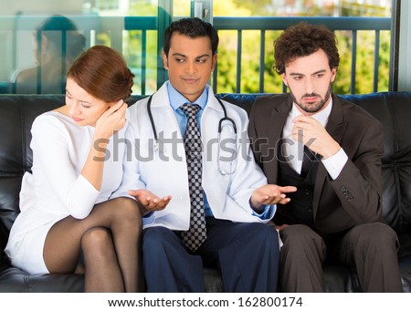 Closeup portrait of psychiatrist sitting on black couch caught in between depressed couple man and woman, frustrated arms up in doctor\'s office, isolated on city urban background. Healthcare debate