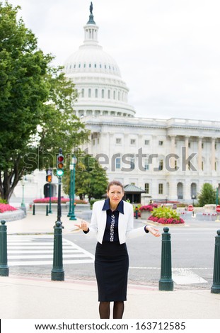 Closeup portrait of young clueless professional, federal employee, politician, businesswoman, executive, who can\'t answer the question, isolated on background Washington DC Capitol USA. Politics