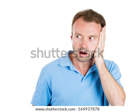 Closeup portrait of wild, goofy, crazy, funny, shocked surprised stunned man\'s face looking to side with copy space to left, isolated on white background. Negative human emotion facial expression