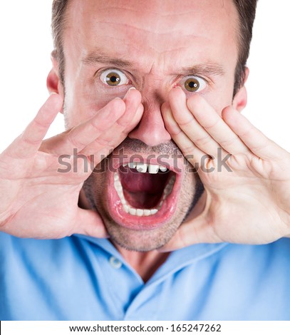 Closeup portrait of angry pissed off irritated guy wearing blue shirt, hands to mouth, screaming, shouting, yelling angry isolated on white background. Negative human emotion facial expression