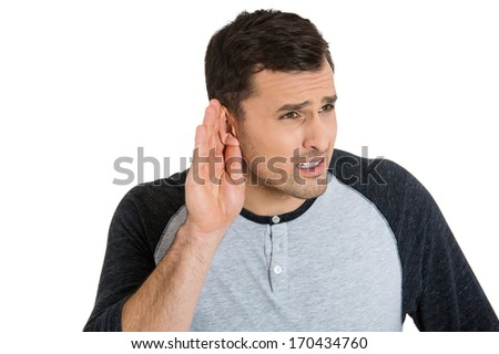 Closeup portrait of handsome young nosy man hand to ear trying to carefully intently secretly listen in on a juicy gossip conversation, privacy violation, isolated on white background