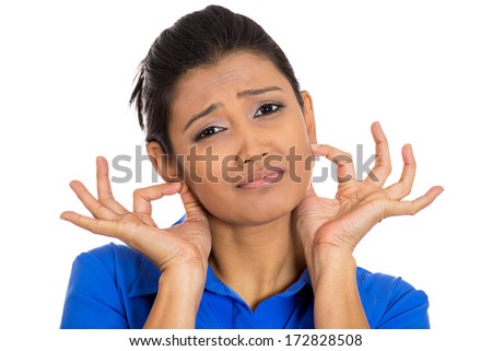 Closeup portrait of pretty young woman pulling gripping ears sorry for what she did, isolated on white background. Negative human emotions, facial expressions, feelings, signs symbols, body language