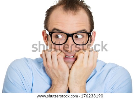 Closeup portrait of nervous stressed young nerdy guy, funny man with eyeglasses biting fingernails looking anxiously craving something isolated on white background. Negative emotion expression feeling