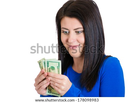 Closeup portrait of super happy excited successful young woman, holding money dollar bills in hand, isolated on white background. Positive emotions, facial expression feeling. Financial reward savings