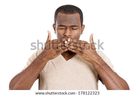 Closeup portrait of silent young man covering closed mouth and eyes. Speak no evil concept, isolated white background. Negative human emotions, facial expressions signs and symbols. Media news coverup
