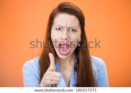 Closeup portrait of angry young woman, student, worker accusing, pointing at you with index finger, isolated orange, red background. Negative human emotion, facial expression, feeling symbol, attitude