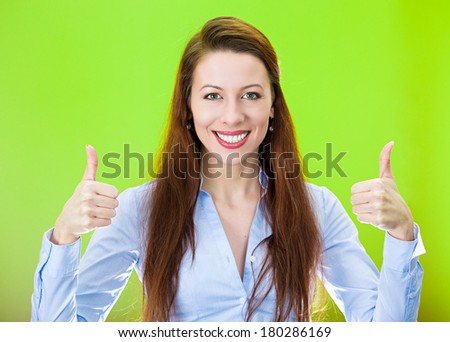 Closeup portrait of pretty, friendly, pleased young smiling business woman giving two thumbs up at camera sign isolated on green background. Positive human emotions facial expression feelings. Symbols