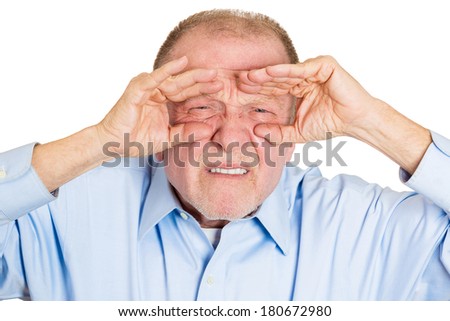 Closeup portrait of senior mature curious man, looking through his fingers like binoculars, searching for something, unhappy disgusted with what is waiting in the future, isolated on white background