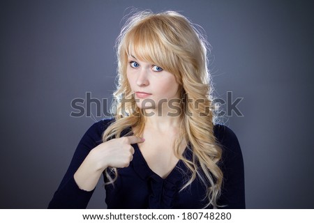 Closeup portrait of angry, unhappy annoyed young woman, student getting mad asking question you talking to, mean me? Isolated on black blue, grey background. Negative human emotions, facial expression