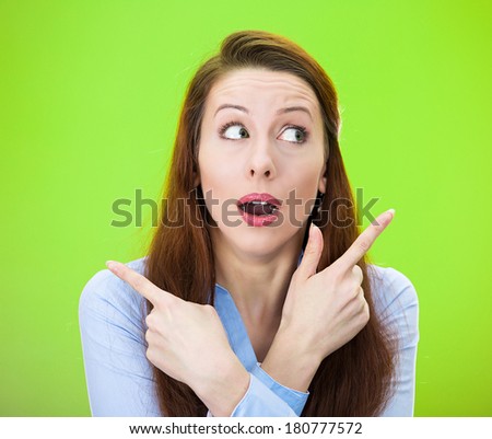 Closeup portrait of confused young woman pointing in two different directions, not sure which way to go in life, isolated on green background. Negative emotion facial expression feeling body language