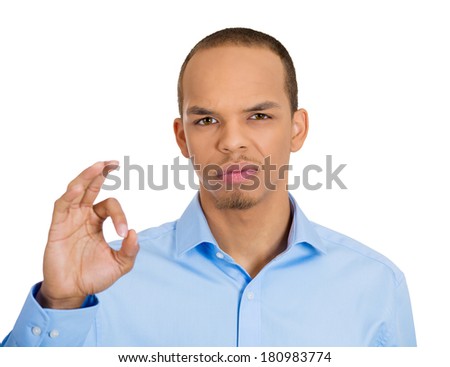 Closeup portrait of sarcastic, young, funny looking, poker face, sly man showing ok sign but has something else on his mind, plotting, isolated white background. Human emotion, expression, attitude