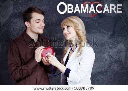 Closeup portrait of couple, smiling female blonde doctor with stethoscope listening to red heart held in hands by happy man student employee isolated grey background. Obamacare, universal health plan