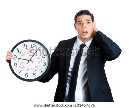 Closeup portrait of business man, funny worker holding clock stressed, running out pressured by lack of time, trying to stop, hold it, late for meeting, isolated on white background. Negative emotion
