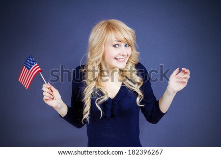 Closeup portrait happy, smiling excited blonde woman, employee, worker, student holding united states of america flag, USA, isolated dark blue background. Positive emotions, face expressions, attitude