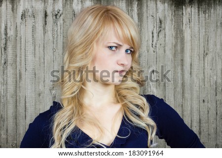 Closeup portrait skeptical young mad woman looking suspicious, disgust face mixed with disapproval isolated wood fence background. Negative human emotion facial expression, feeling, attitude, reaction