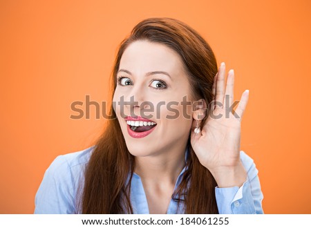 Closeup portrait of carefully listening to someone\'s conversation, nosy woman with hand to ear, looking surprised shocked by what she just discovered isolated, orange background. Human emotions