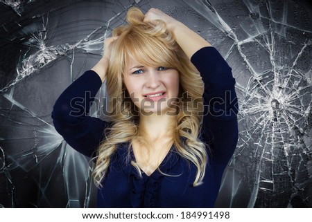 Closeup portrait, goofy, funny face, young woman pulling hair frustrated annoyed isolated blue gray background, shattered, broken glass. Negative human emotion facial expression feeling, body language