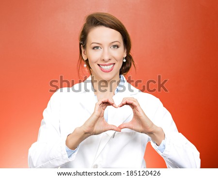 Closeup portrait smiling, cheerful health care professional, pharmacist, dentist, nurse making heart sign with hands, isolated red background. Positive human emotions, facial expressions, feelings