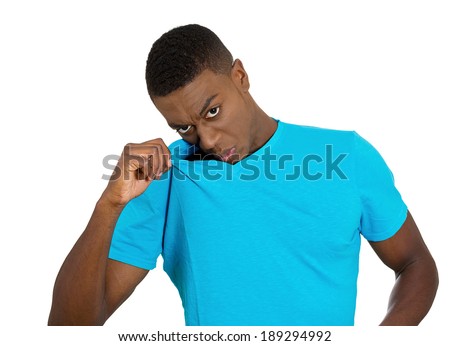 Closeup portrait, young man, smelling, sniffing himself, something stinks, very bad smell, odor. Guy sniffs himself. Isolated white background Negative emotion, facial expression, feeling