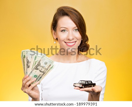 Closeup portrait, young business woman, bank agent, representative holding model black car, green dollar cash bills in hand, isolated yellow background.Lease offers, credit line, financing, dealership