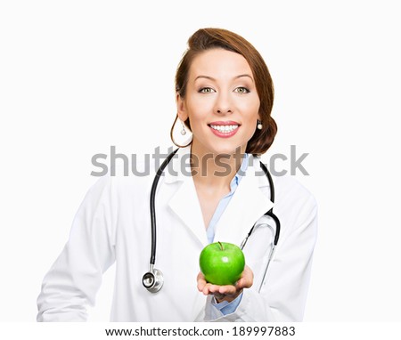Closeup portrait, confident happy health care professional, doctor, nurse in lab coat, offering you fruit, isolated white background. Apple a day keeps doctor away concept. Nutrition, healthy diet
