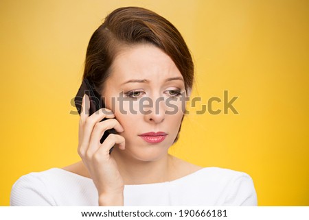 Closeup portrait upset, sad, depressed, unhappy worried brunette woman talking on phone, isolated yellow background. Negative human emotions, facial expressions, feelings, life reaction. Bad news.
