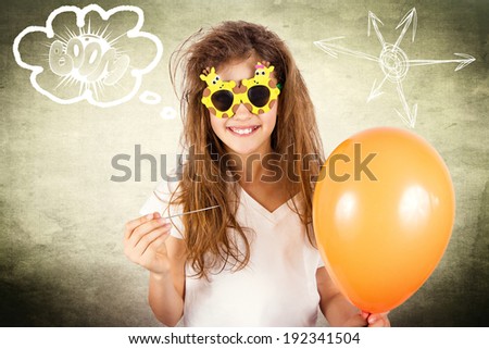 Closeup portrait happy, smiling, funny looking little girl with sunglasses, holding orange balloon and needle about to burst bubble isolated background with sun. Human face expression, emotion feeling