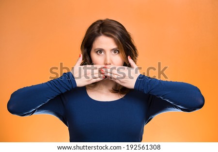Closeup portrait young business woman covering closed mouth. Speak, no evil concept, isolated orange background. Negative human emotions, facial expressions, reaction, sign, symbol. Media news coverup