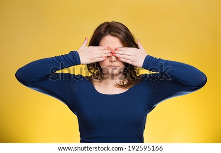 Closeup portrait young middle aged woman, closing, covering eyes with hands can\'t look, hiding, avoiding situation, isolated yellow background. See no evil concept. Human emotions, facial expressions