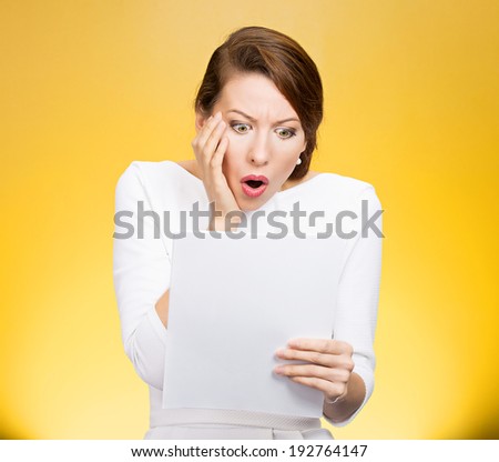Closeup portrait shocked, funny looking young woman, disgusted at monthly statement, test, application, results isolated yellow background. Negative human emotion, facial expression, feeling. Bad news