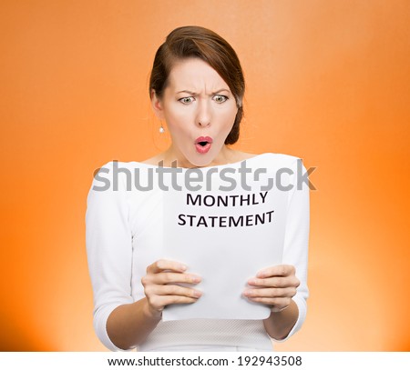 Closeup portrait shocked, funny looking business woman, disgusted at monthly statement, can't believe her eyes, isolated orange background. Negative human emotion, facial expression, feeling. Bad news